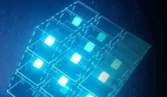 A glowing, translucent 3D cube composed of smaller illuminated cubes floating against a dark blue background, with bright white and blue lights highlighting the structure.